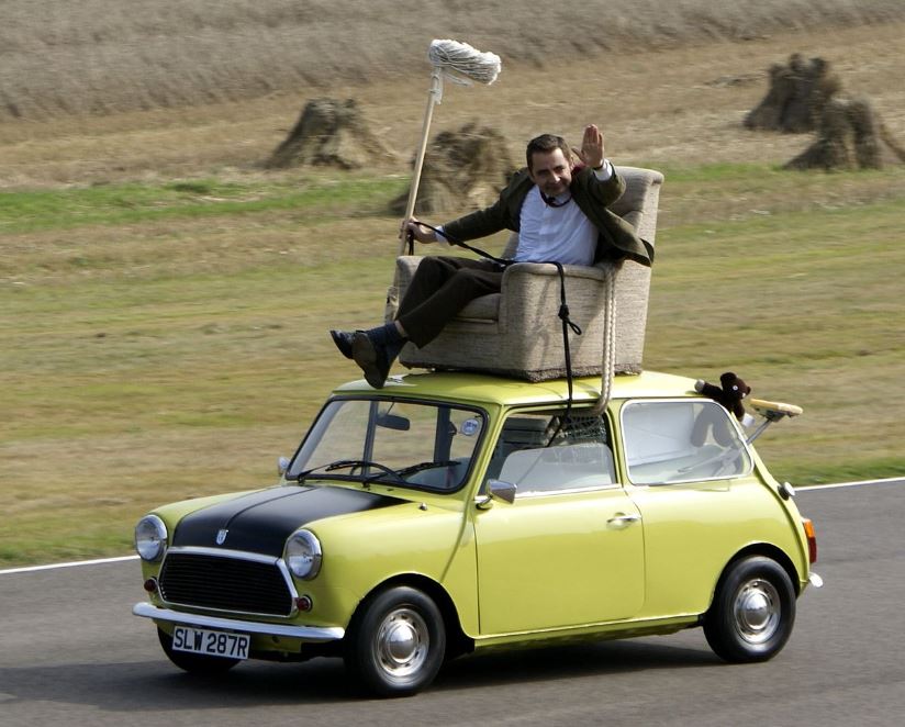 Mr Bean assis dans un fauteuil fixé sur le toit de sa Mini classique