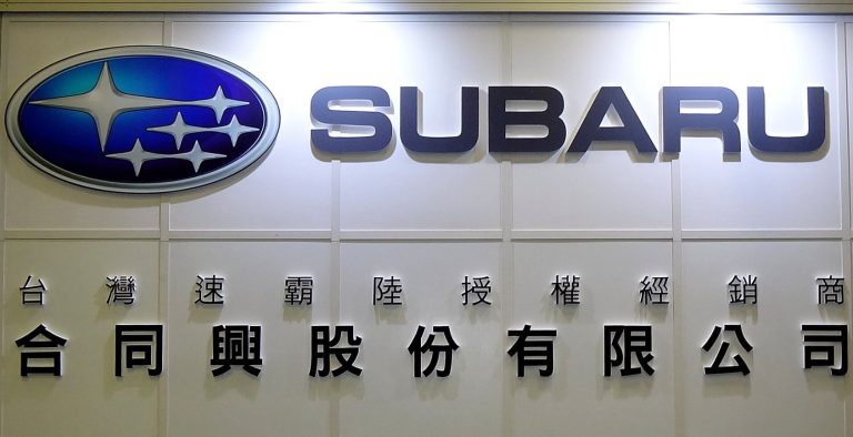 Logo Subaru et nom de la marque sur la façade d'une concession automobile