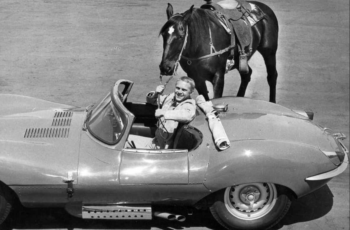 Steve McQueen au volant de sa Jaguar XKSS avec son cheval à proximité