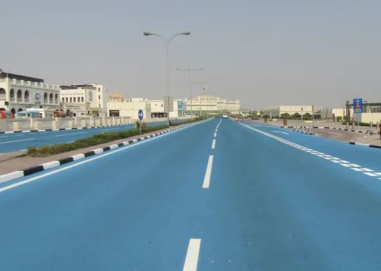 Revêtement routier clair limitant l'accumulation de chaleur dans un environnement urbain exposé au soleil.