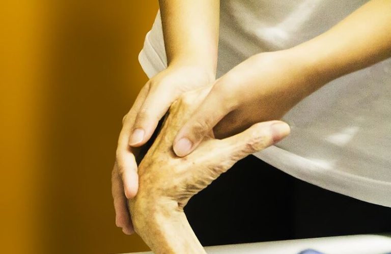 Main d'un soignant tenant celle d'une personne âgée, illustration de l'accompagnement en fin de vie.