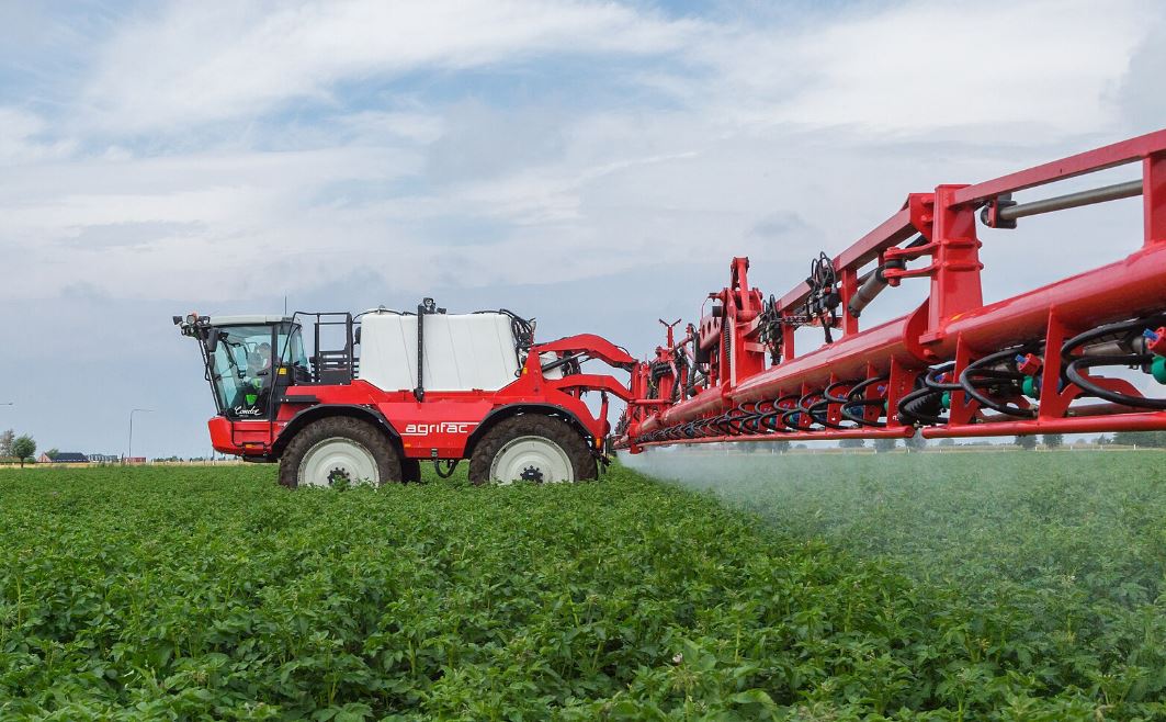 Pulvérisateur agricole traitant une culture, illustration du débat sur les néonicotinoïdes et les réglementations agricoles en Europe.