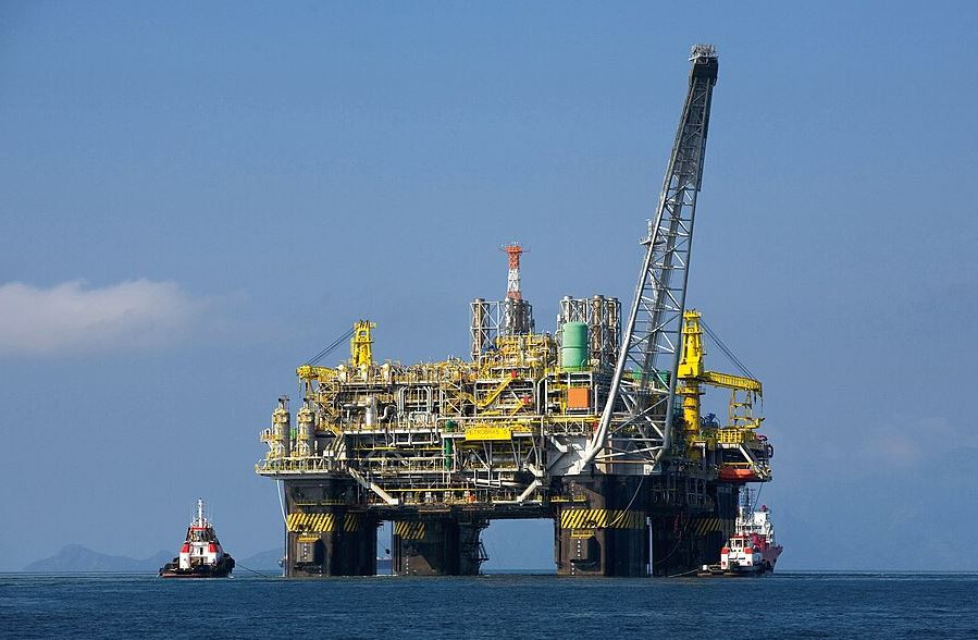 Plateforme pétrolière en mer illustrant l'influence du pétrole sur les prix des carburants.