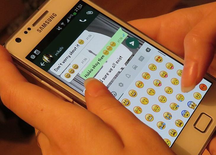 Personne utilisant une application de messagerie sur un smartphone au lieu de passer un appel téléphonique.