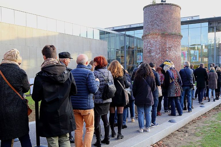 File d'attente devant un bâtiment public, illustrant le temps d'attente devenu une réalité fréquente dans la vie quotidienne et l'accès aux services.