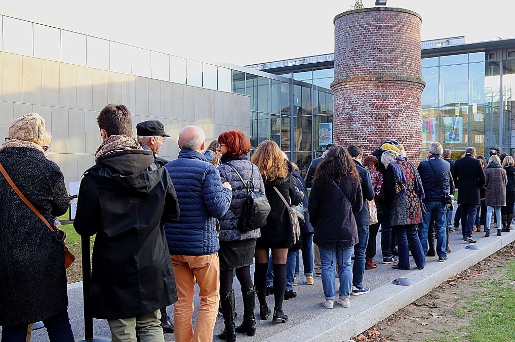 File d'attente devant un bâtiment public, illustrant le temps d'attente devenu une réalité fréquente dans la vie quotidienne et l'accès aux services.