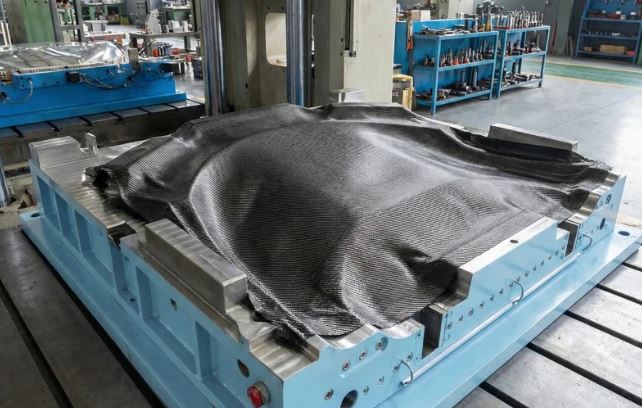 Fabrication d'une pièce en fibre de carbone sur un moule avant polymérisation