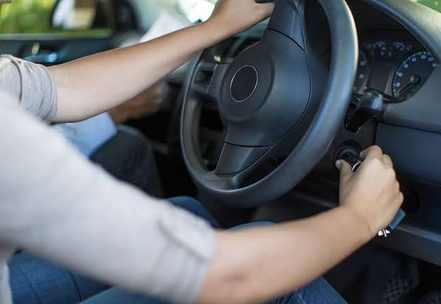 Conducteur tentant de redémarrer un moteur essence difficile à chaud