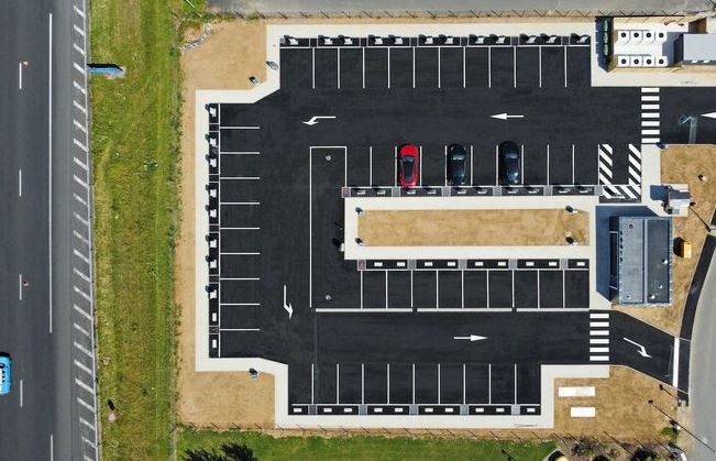 Vue aérienne d'une station de recharge pour voitures électriques aménagée le long d'une autoroute
