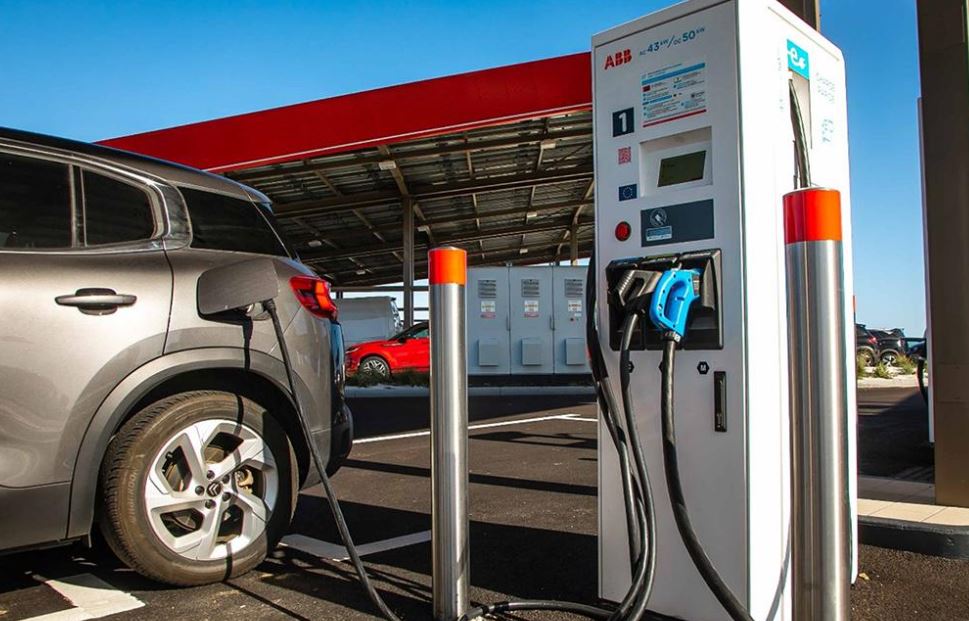 Voiture électrique branchée sur une borne de recharge rapide d'une aire d'autoroute