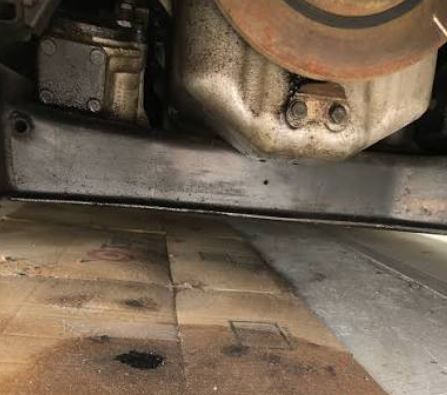 Tache d'huile sous une voiture anglaise illustrant la réputation de certaines mécaniques britanniques
