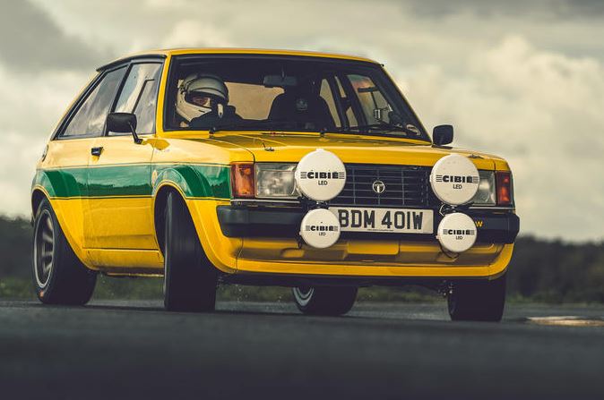 Talbot Sunbeam Lotus de rallye aux couleurs jaunes et vertes avec quatre projecteurs Cibié