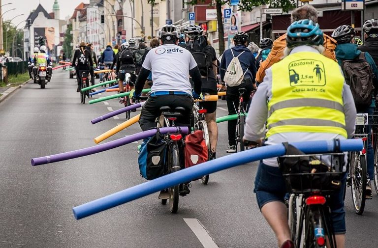 Cyclistes portant un casque et un gilet réfléchissant lors d'un déplacement en ville.