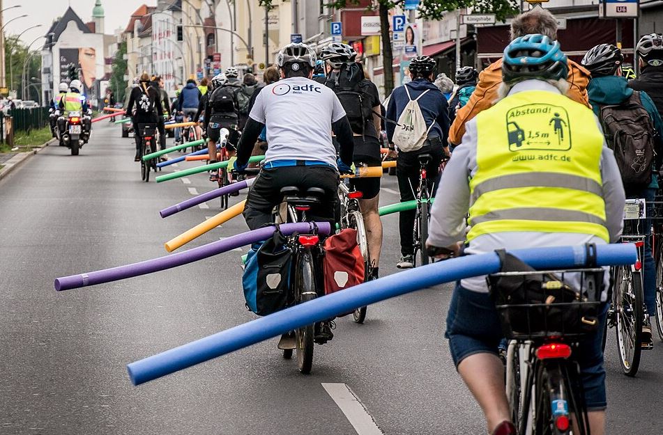 Cyclistes portant un casque et un gilet réfléchissant lors d'un déplacement en ville.