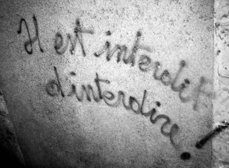 Graffiti « Il est interdit d’interdire » sur un mur, illustration du débat entre interdire et réglementer.