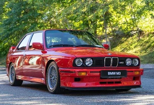 BMW M3 E30 rouge vue de trois quarts avant