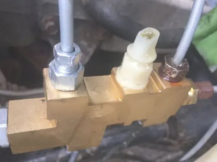 Répartiteur de freinage présentant une fuite au niveau d'un raccord hydraulique