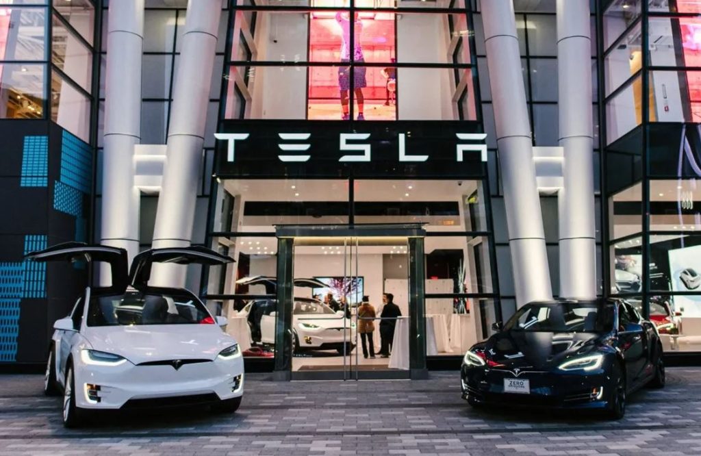 Concession Tesla avec plusieurs voitures électriques exposées devant le showroom