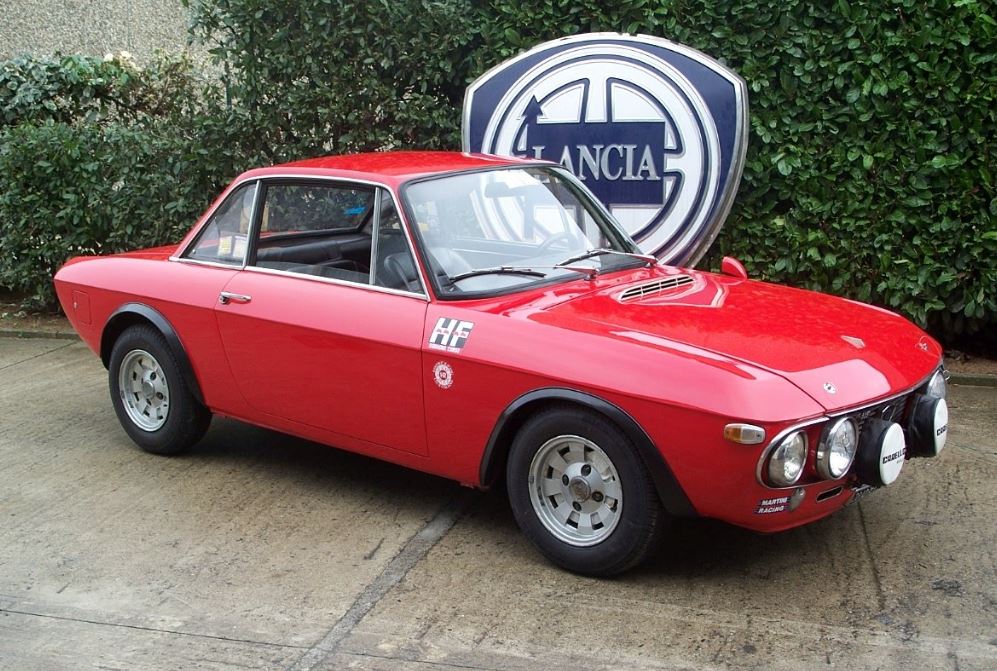 Lancia Fulvia Coupé 1.6 HF Fanalone rouge devant le logo Lancia