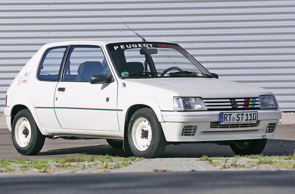 Peugeot 205 Rallye blanche vue de trois quarts avant avec ses bandes Peugeot Sport