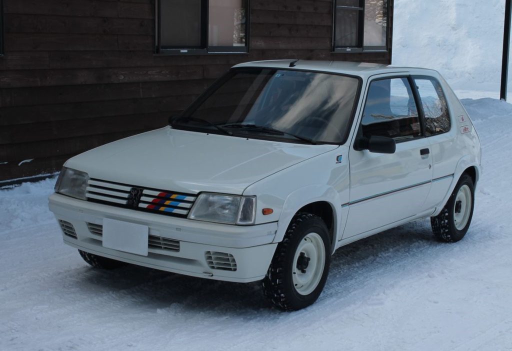 Peugeot 205 Rallye blanche vue de trois quarts avant gauche sur la neige