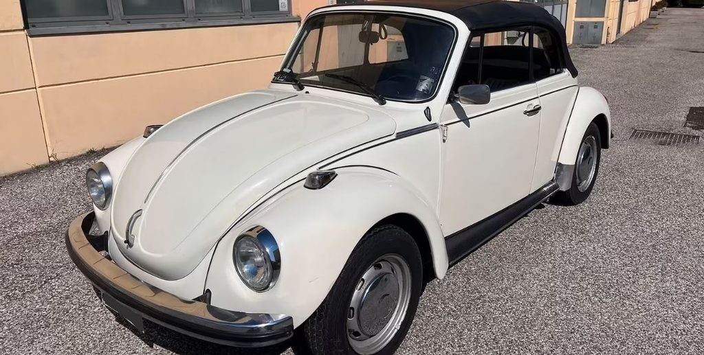 Volkswagen Coccinelle cabriolet 1970 blanche parmi les sorties de grange