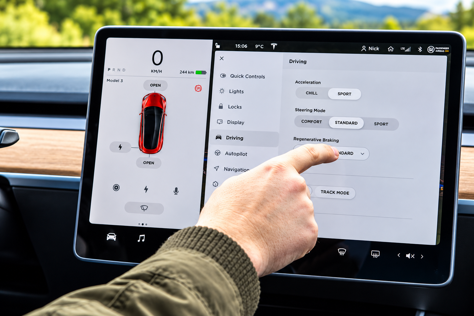 Main d’un conducteur utilisant l’écran tactile central d’une Tesla Model 3 pour modifier les réglages de conduite, illustrant les risques de distraction au volant.
