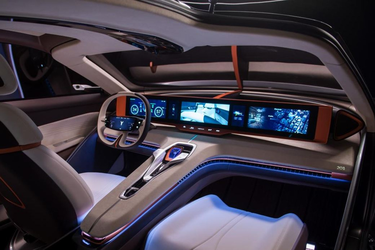 Intérieur d'une voiture de luxe futuriste avec plusieurs écrans numériques sur toute la largeur du tableau de bord, sièges blancs et éclairage d'ambiance bleu.
