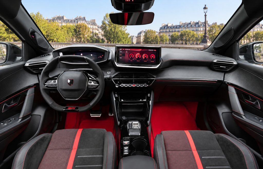 Habitacle de la Peugeot E-208 GTi avec sièges sport, volant GTi et tableau de bord noir et rouge