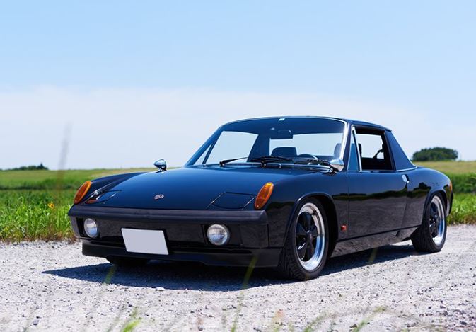 Porsche 914 1.7 noire photographiée de trois quarts avant, avec ses phares escamotables fermés et son toit Targa.