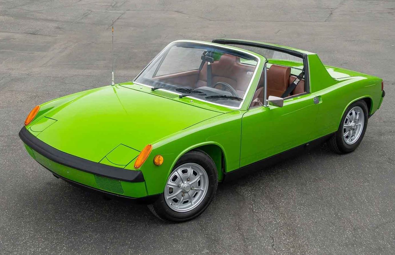 Porsche 914 verte photographiée de trois quarts avant, avec toit Targa retiré, phares escamotables fermés et intérieur marron.