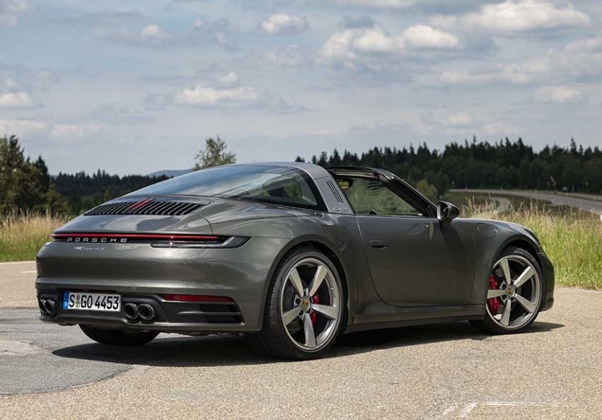 Porsche 911 Targa 4S grise photographiée de trois quarts arrière, avec son toit ouvert.
