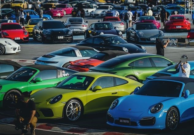 Rassemblement de Porsche 911 de différentes générations et couleurs, symbole du succès durable du modèle.