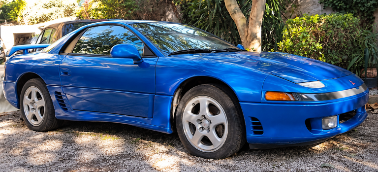 Mitsubishi 3000GT VR4 bleue de 1991, sportive japonaise à transmission intégrale retrouvée en extérieur, avec son aileron arrière.