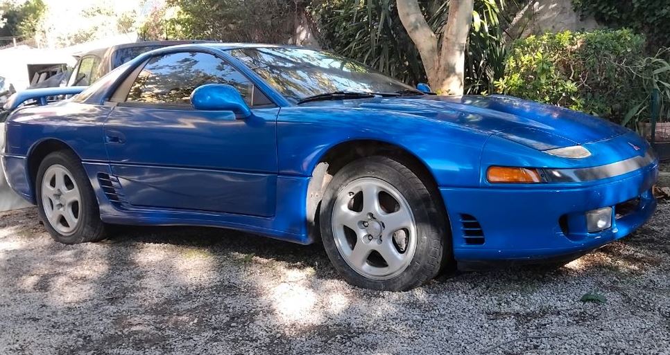 Mitsubishi 3000GT VR4 bleue de 1991, sportive japonaise à transmission intégrale retrouvée en extérieur, avec son aileron arrière.