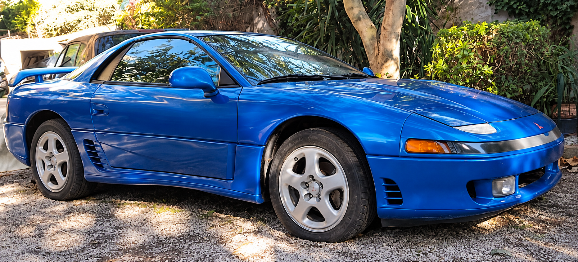Mitsubishi 3000GT VR4 bleue de 1991, sportive japonaise à transmission intégrale retrouvée en extérieur, avec son aileron arrière.