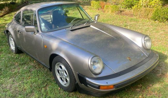 Porsche 911 SC 3.0 de 1983 grise stationnée dans un jardin après une période d'immobilisation