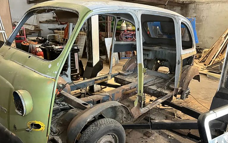 Fiat 600 Multipla de 1957 en cours de restauration dans un atelier, carrosserie partiellement démontée et habitacle entièrement dépouillé.