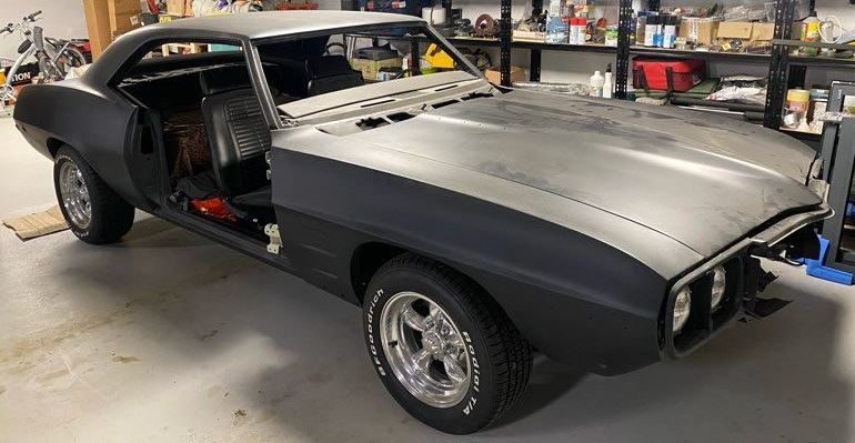 Pontiac Firebird de 1969 en cours de restauration, carrosserie en apprêt et éléments démontés