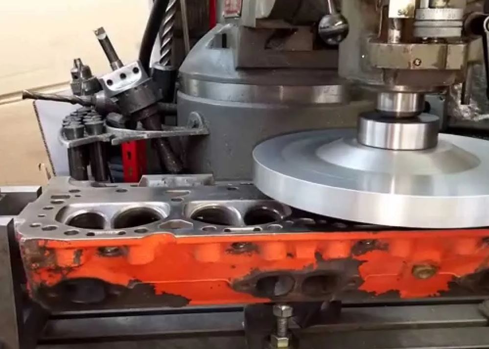 Surfaçage d'une culasse de moteur thermique, opération réduisant le volume de chambre et augmentant le taux de compression.