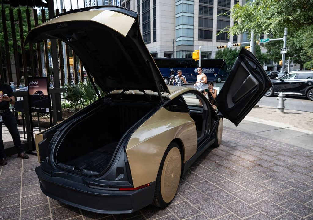 Tesla Cybercab photographié à Austin, avec son grand coffre arrière ouvert et une porte papillon relevée.