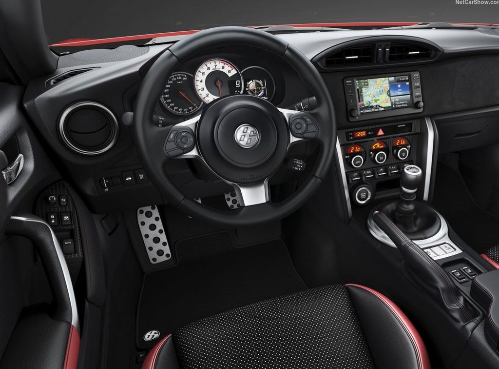 Tableau de bord de Toyota GT86 avec volant sport, compte-tours central, sièges baquets et boîte manuelle à six rapports.