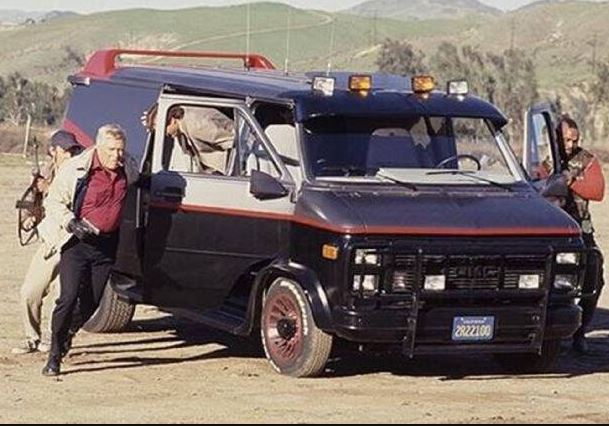 GMC Vandura de L'Agence tous risques entouré des personnages de la série, lors d'une scène en extérieur.