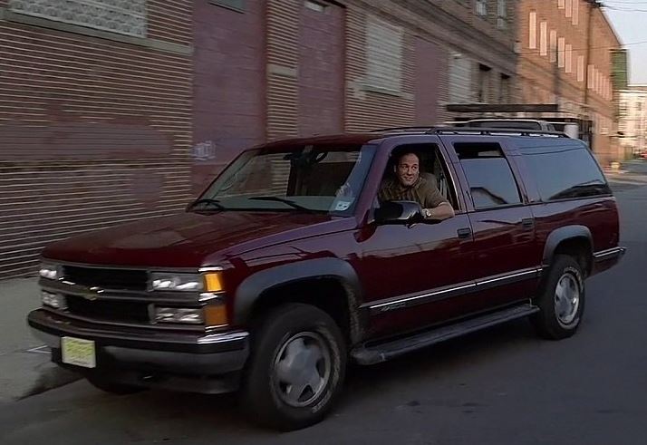 Tony Soprano au volant de son Chevrolet Suburban bordeaux dans une rue du New Jersey.