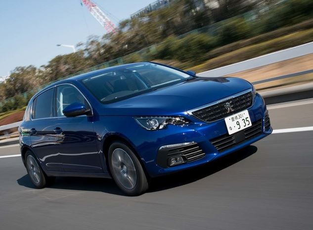 Peugeot 308 bleue à moteur diesel photographiée de trois quarts avant sur une route.